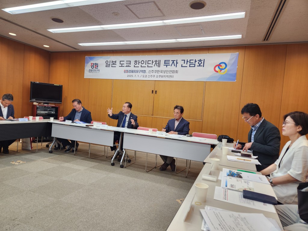 A meeting held in Shinjuku, Tokyo, discussing investment opportunities in Gangwon Economic Free Zone, featuring several attendees at a conference table with presentations and materials.