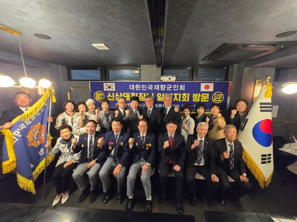 대한민국 재향군인회 일본지회 기념 사진, 참석자들이 손을 흔들며 지지의 표시를 하고 있는 모습.
