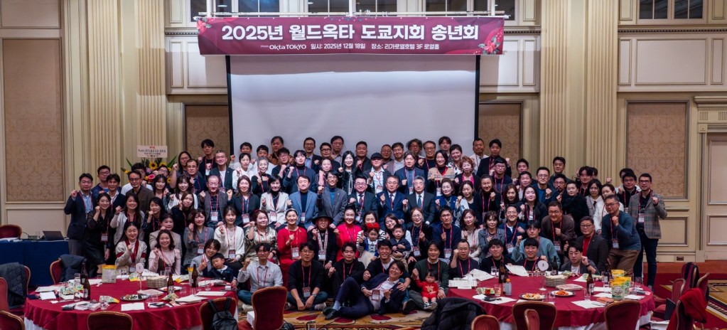 2025년 월드옥타 도쿄지회 송년회 단체 사진, 참석자들이 함께 포즈를 취하고 있는 모습.