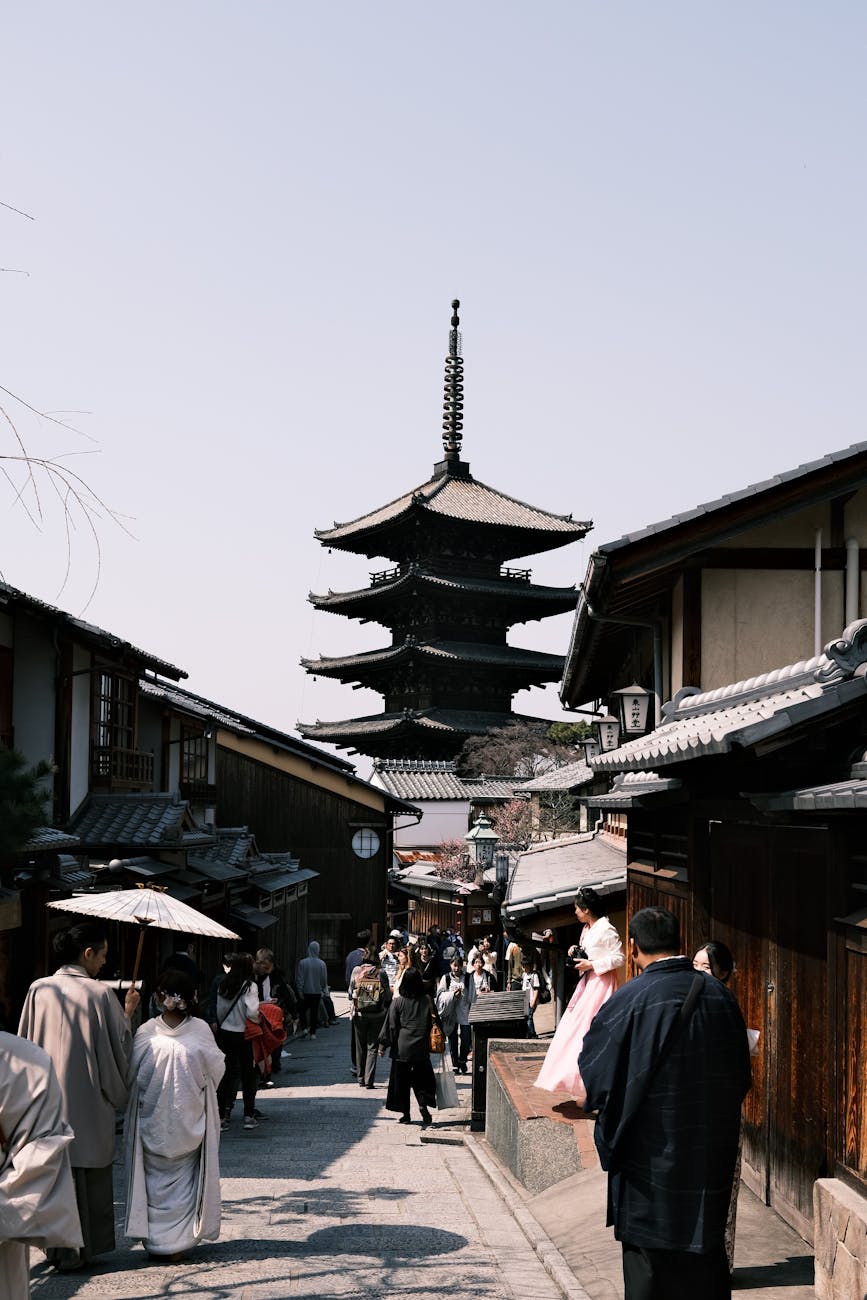 view of people walking on a street toward the hokan ji temple yasaka pagoda in kyoto japan