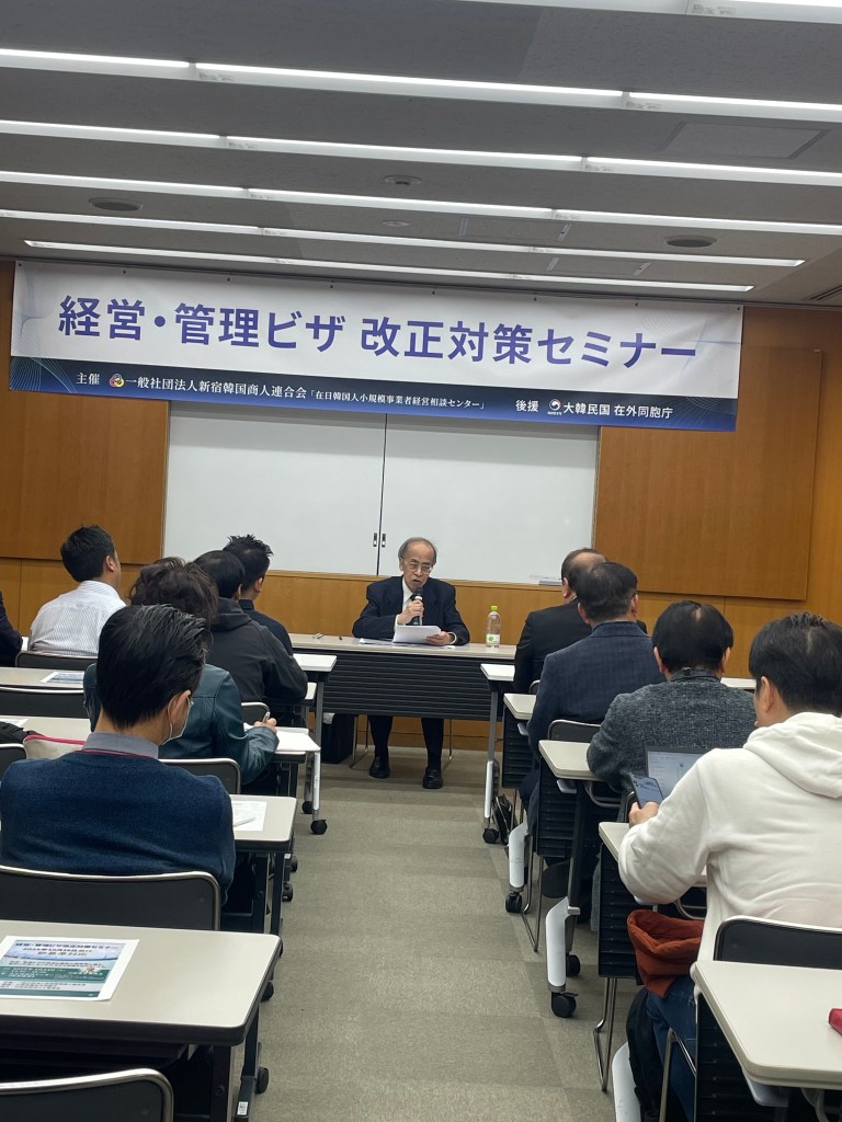 경영 및 관리 비자 개정 대책 세미나에서 발표하는 남성.